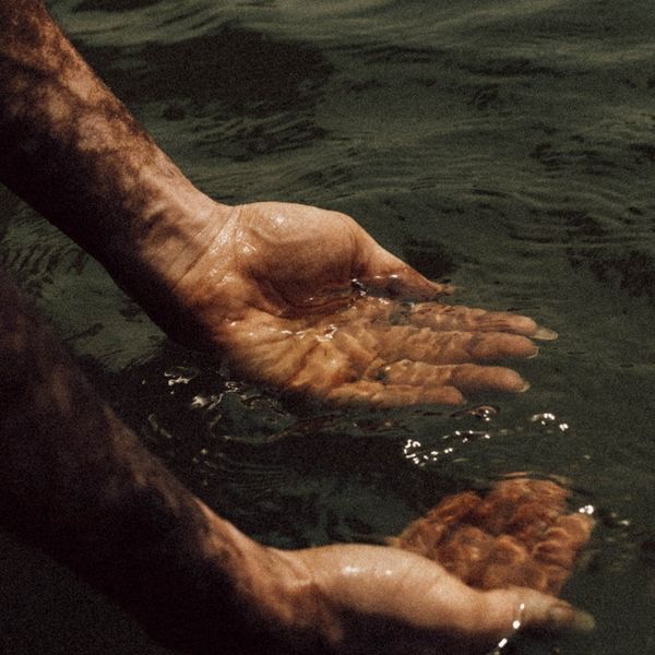 Person stretching gently outdoors with a calm expression.